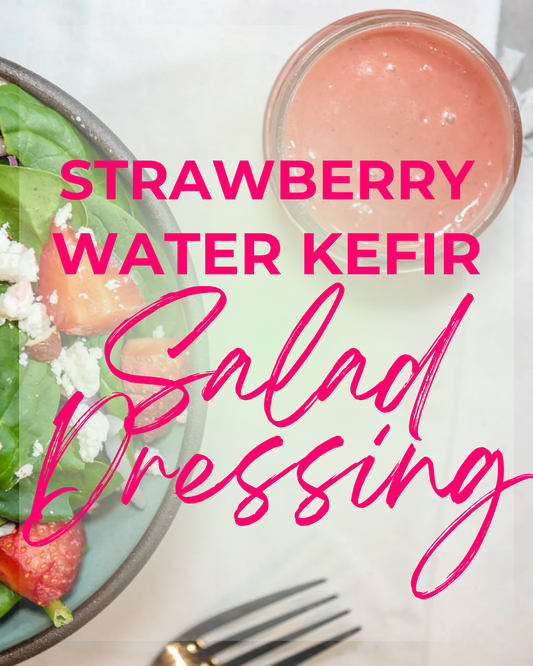 A container of fresh strawberry salad dressing next to spinach, goat cheese and strawberry salad